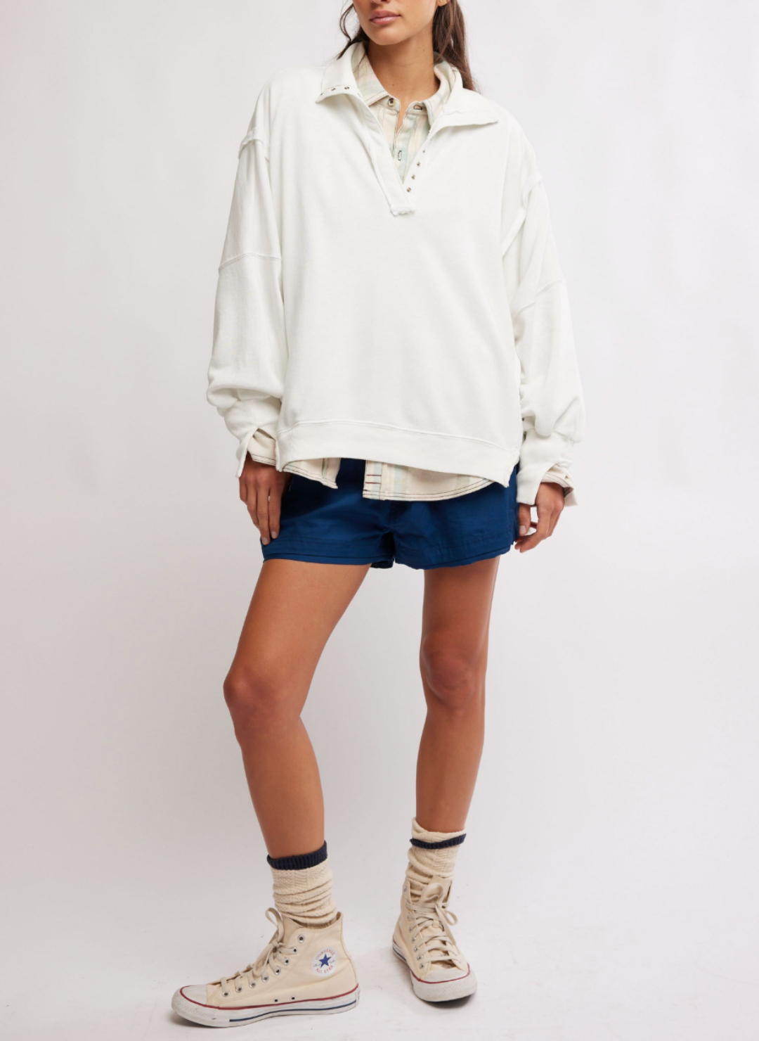 Model is wearing white Camden pullover sweatshirt blue shorts. Models arms are by her side.