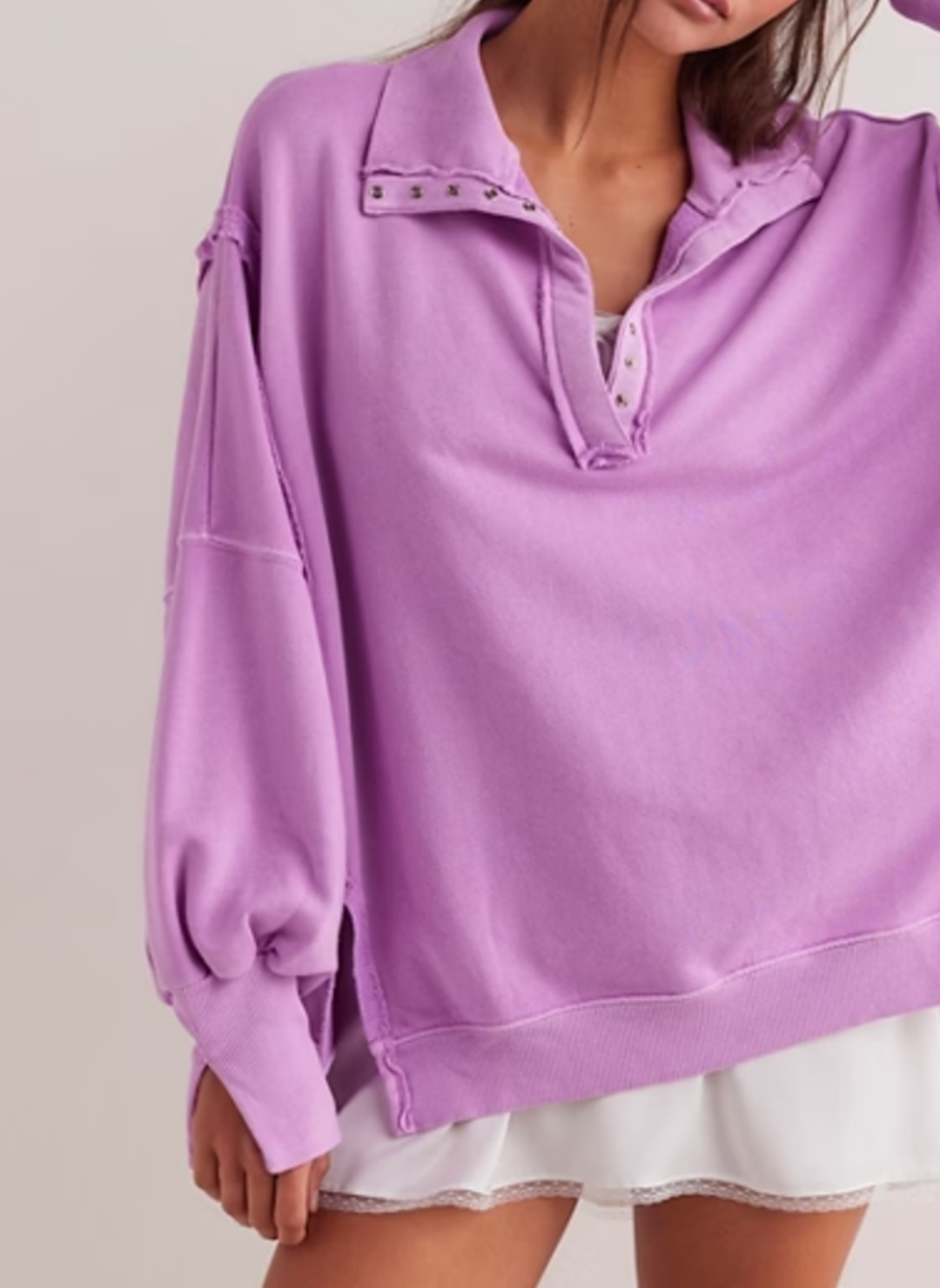 Model is wearing fuchsia colored Camden Pullover Sweatshirt with a white dress underneath.