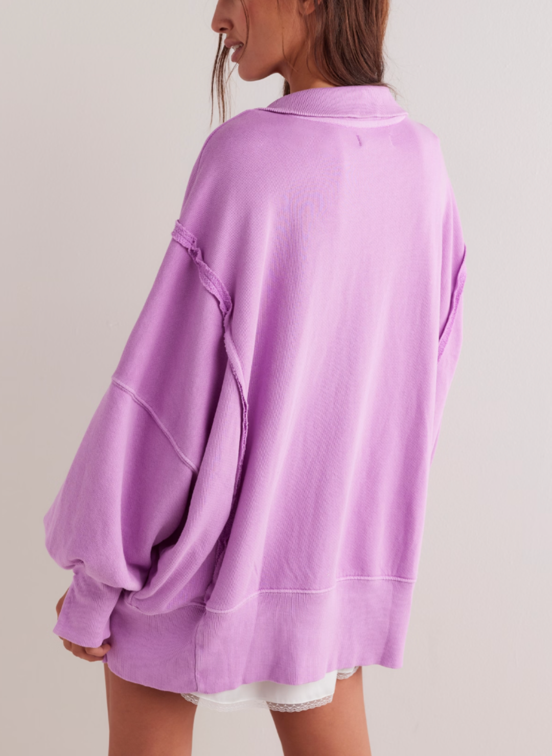 Model turned away wearing fuchsia colored Camden pullover sweatshirt showing the back side of the sweatshirt.