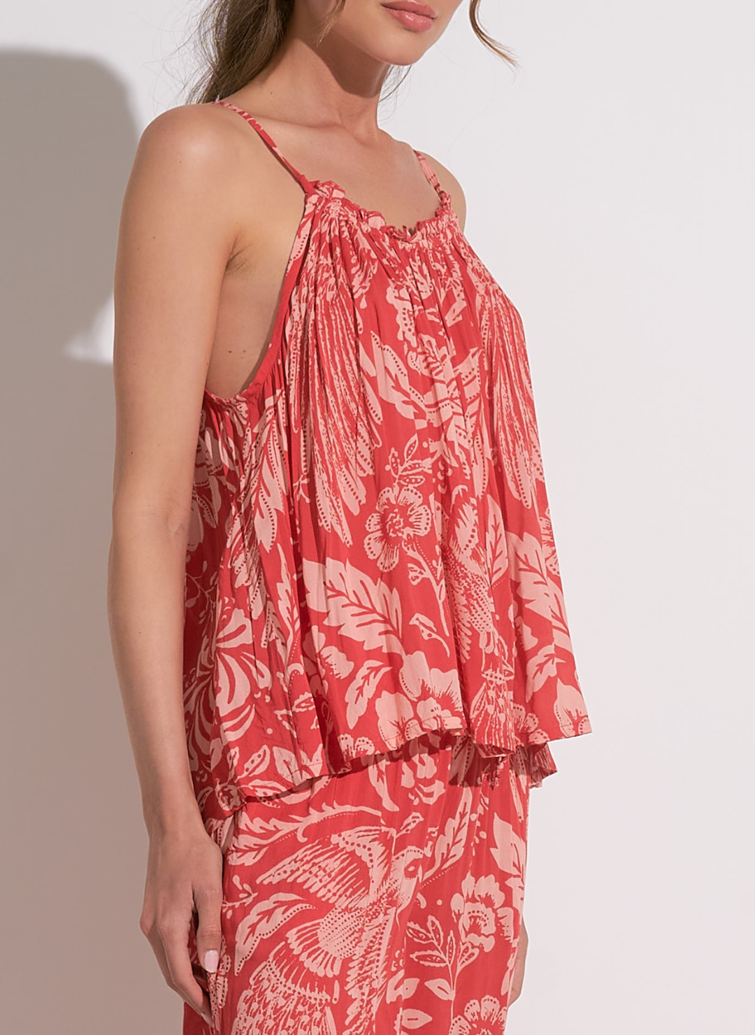 Woman wearing red floral printed smocked tank with adjustable straps, lightweight summer cami top for women, tropical rayon tank from August Boutique.