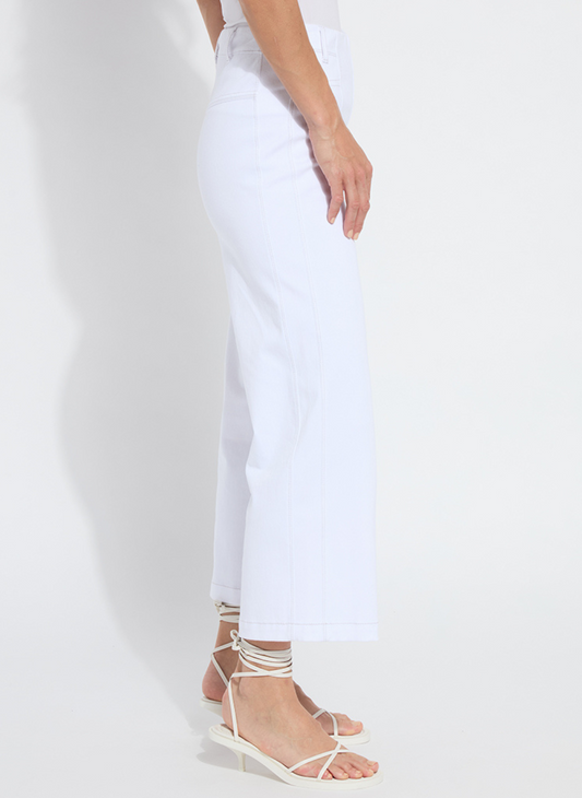 A model wears high-waisted white wide-leg cropped pants made of stretch denim-blend, featuring a clean pull-on waistband, front vertical seams, belt loops, and a hem that finishes above the ankle.