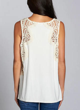 Woman wearing a sleeveless ivory tank top with intricate crochet lace detailing on the shoulders and upper back. The Lovestitch Crochet Tank features a soft cotton gauze front, knit jersey back, and relaxed boho-inspired fit—perfect for boutique-style summer outfits.