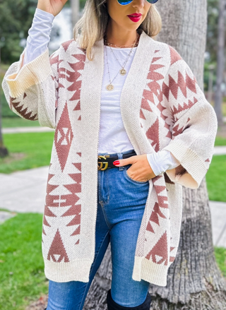 Model is wearing southwest printed open cardigan. Models one hand is in pocket to display the sleeve and overall fit.