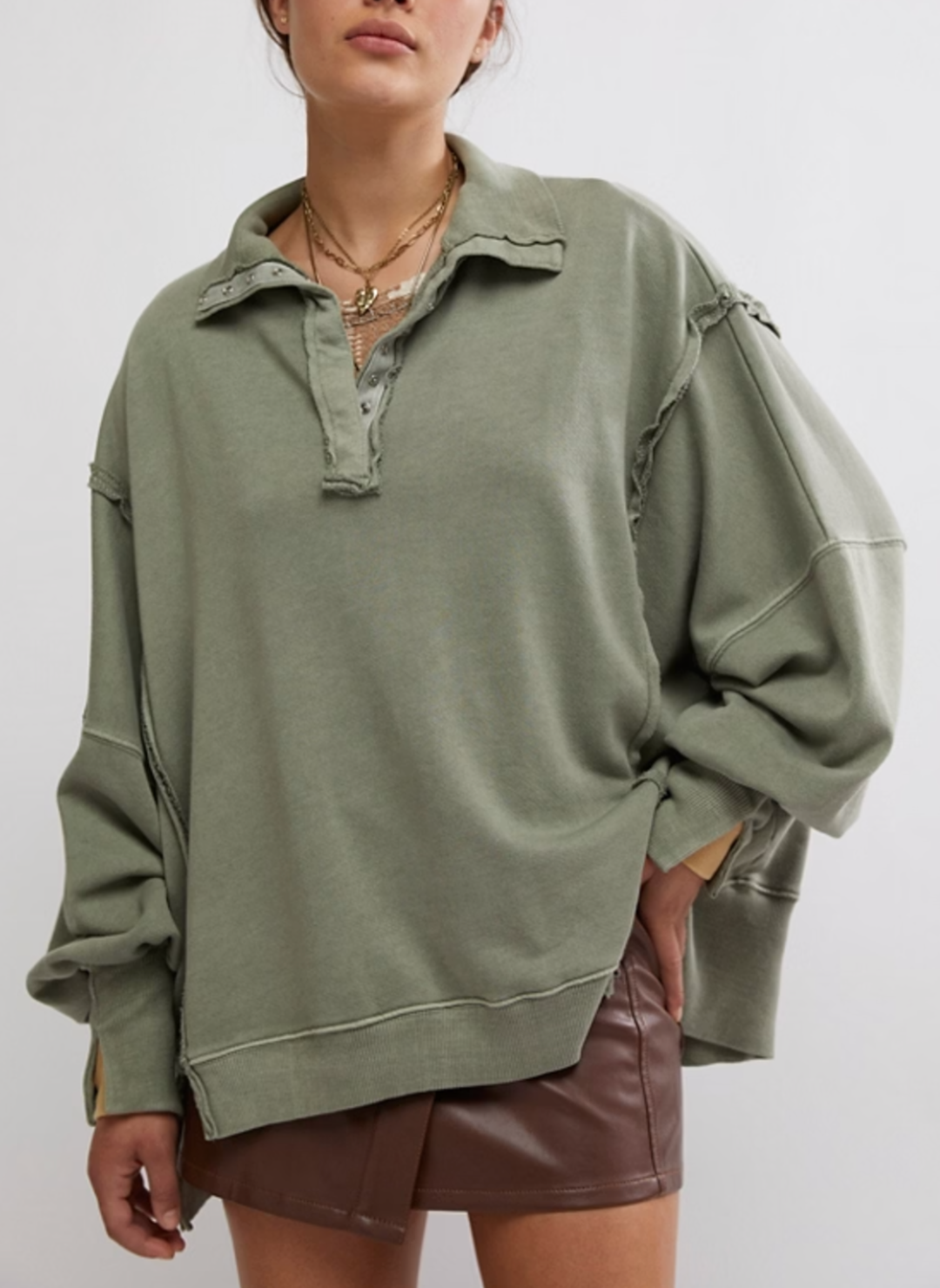 Model is wearing green Camden pullover sweatshirt with a brown leather skirt.