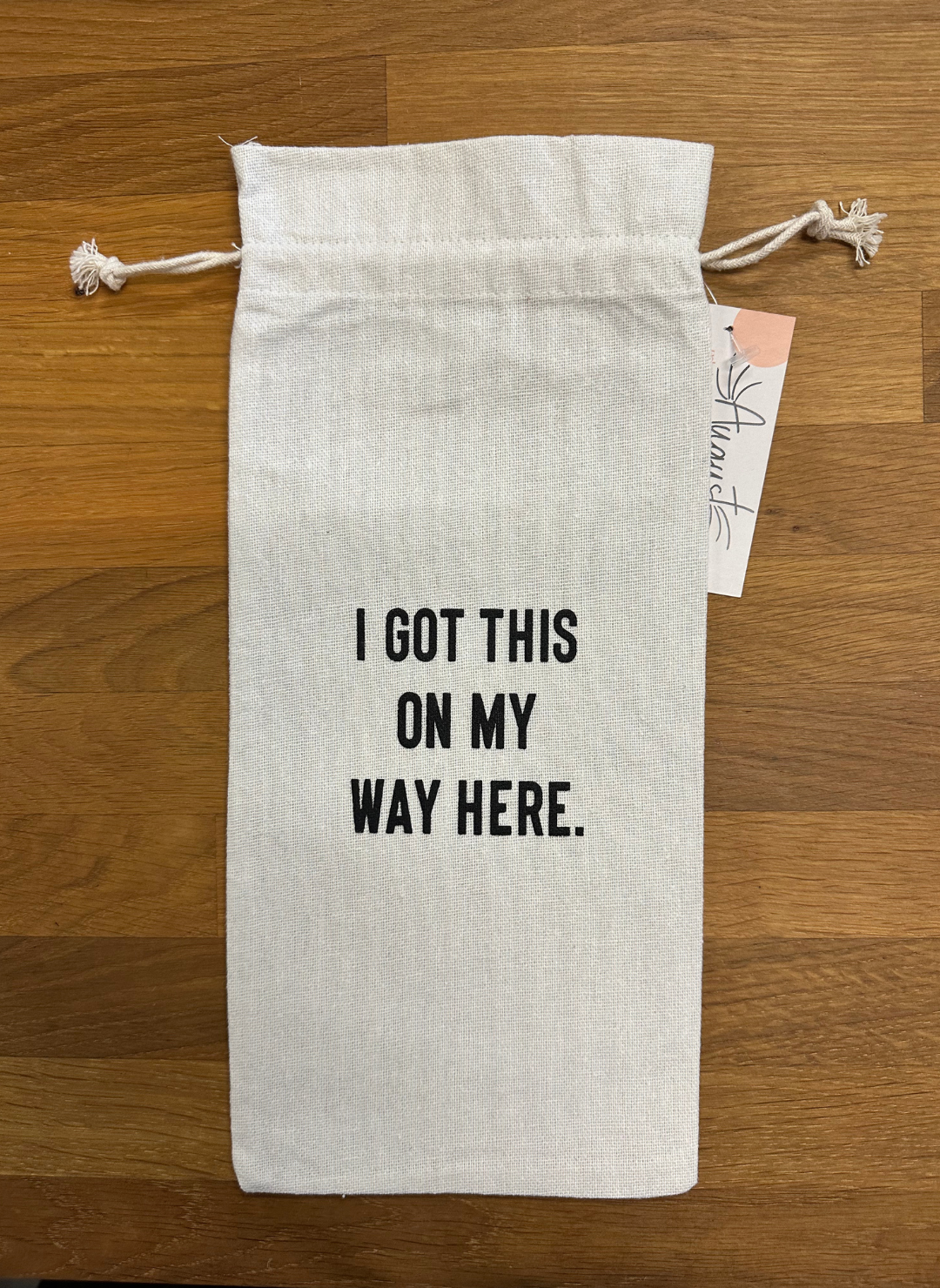 Image shows a wine bag with string drawcord that says “I got this on my way here.”