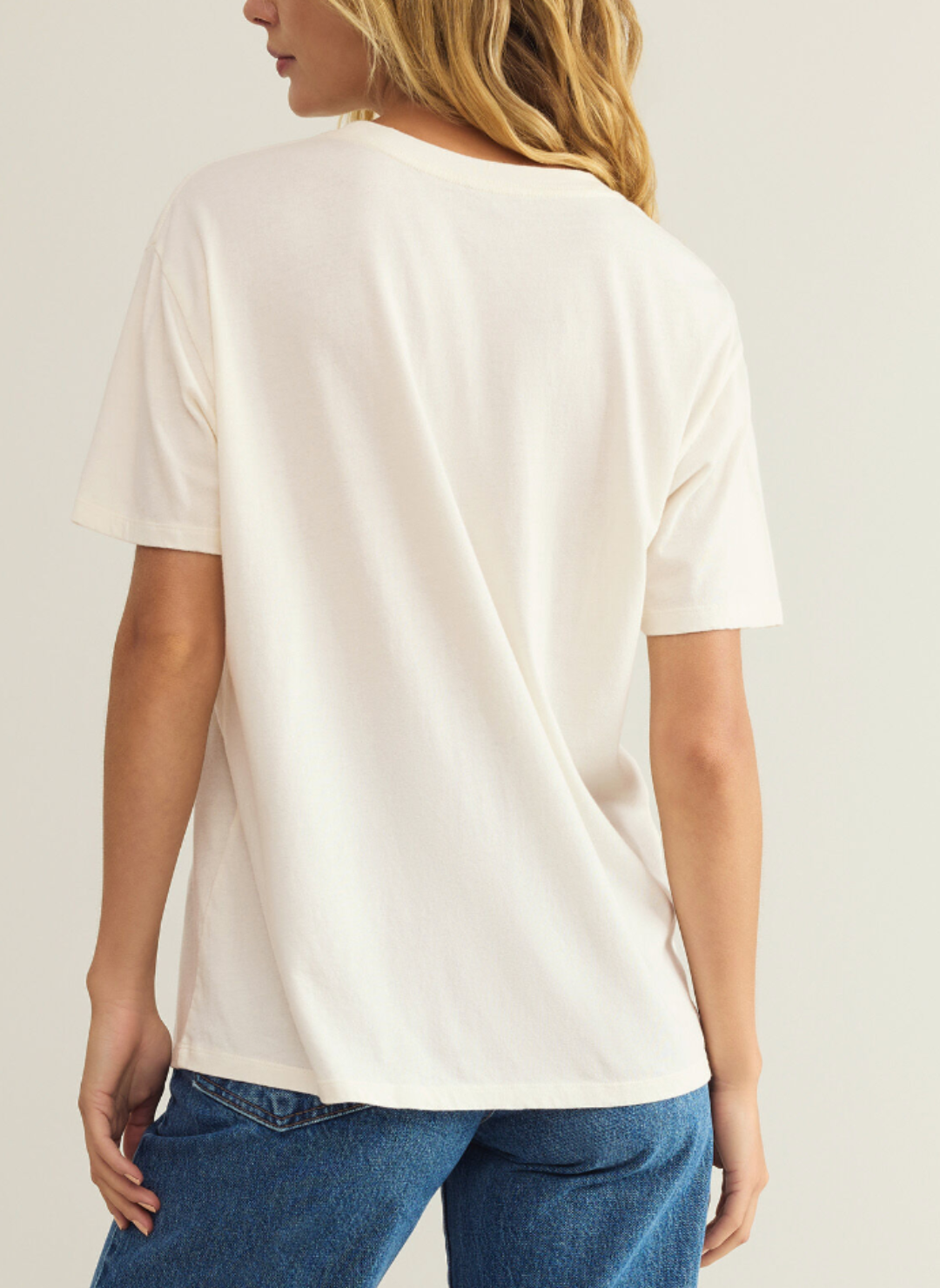 Model is wearing cream colored Big LOVE BF tee and showing the backside of the shirt.