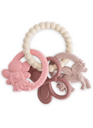 Mushie Fairy Teething Ring in soft pastel tones, featuring a textured silicone ring with pink butterfly, unicorn, and fairy princess charms