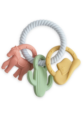 Mushie Western Teething Ring featuring a textured silicone loop with three attached Western-themed charms: a pink horse, green cactus, and yellow cowboy hat