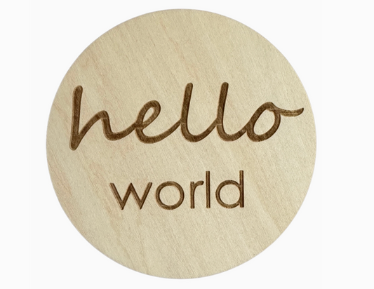 Round wooden coaster with 'hello world' text on a white background