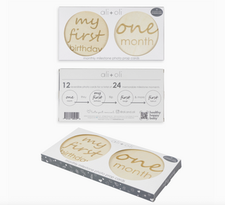 Three boxes of 'my first birthday' milestone photo cards on a white background