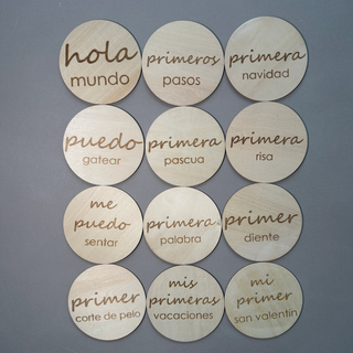 12 round wooden disks with spanish written on them.
