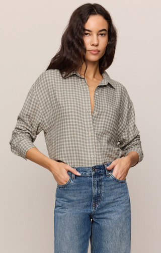 Woman wearing the Z Supply Green Gingham River Plaid long sleeve button-up shirt tucked into high-waisted wide-leg denim jeans.