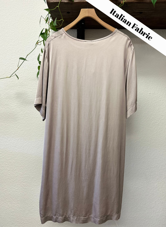 Beige dress on a hanger against a white wall with 'Italian Fabric' text.
