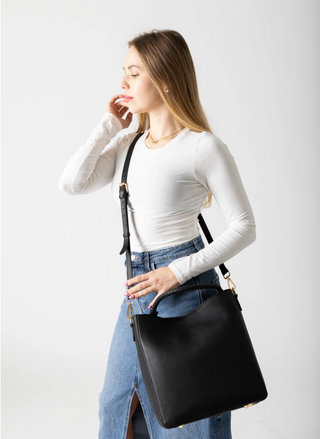 Woman carrying RISA Vancouver Camilla Tote in black upcycled leather, styled with casual chic outfit