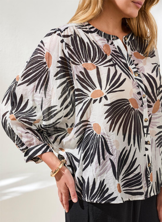 Close-up detail of white and black daisy floral print and soft rayon-polyester fabric texture on Tribal blouse