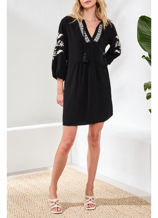 Front view of Tribal Elaine Floral Embroidery Dress in black featuring white embroidered details, v-neckline, and decorative front tassels. 