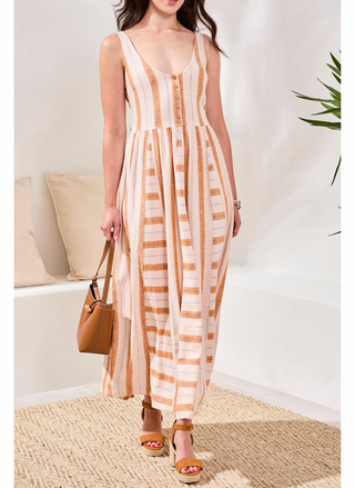 Woman wearing a striped dress holding a handbag in a minimal indoor setting