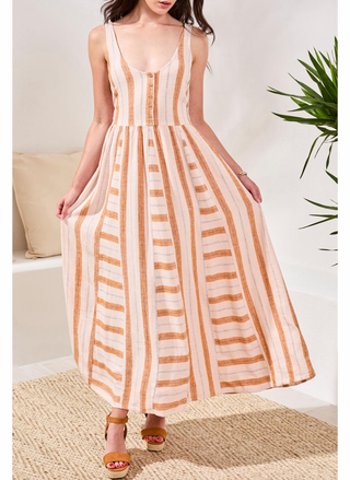 Woman wearing a striped dress in a home setting with a plant in the background