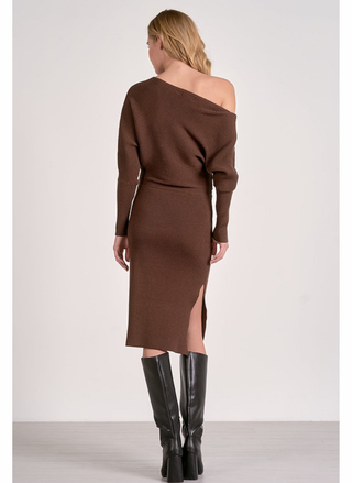 Woman wearing a brown off-shoulder dress with a slit, standing against a white background.