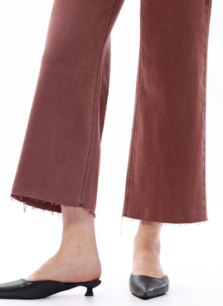 Brown pants with a fringe detail worn by a person on a white background