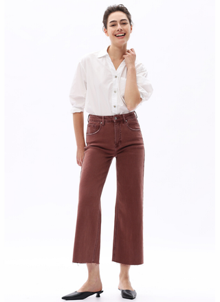 Woman wearing a white blouse and brown pants on a white background.  Bayeas Coffee Break High Rise Wide Leg Denim in coffee brown.
