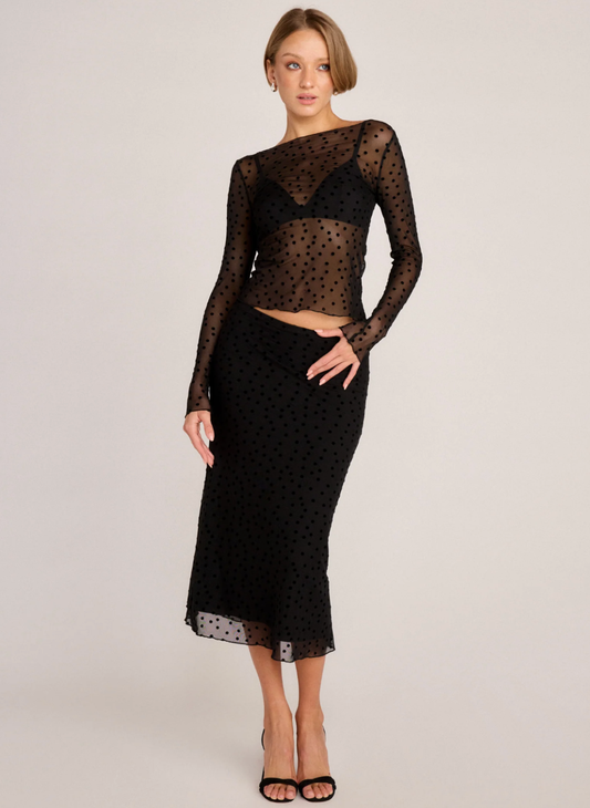 Model wearing Sunday Ritual Polka Dot Whisper Midi Skirt with matching sheer top in black