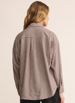 Person wearing a checkered shirt on a beige background