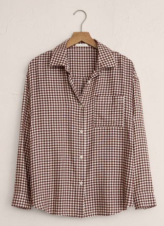 Plaid shirt on a hanger against a white background