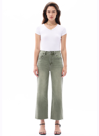 Woman wearing a white t-shirt and green jeans on a white background