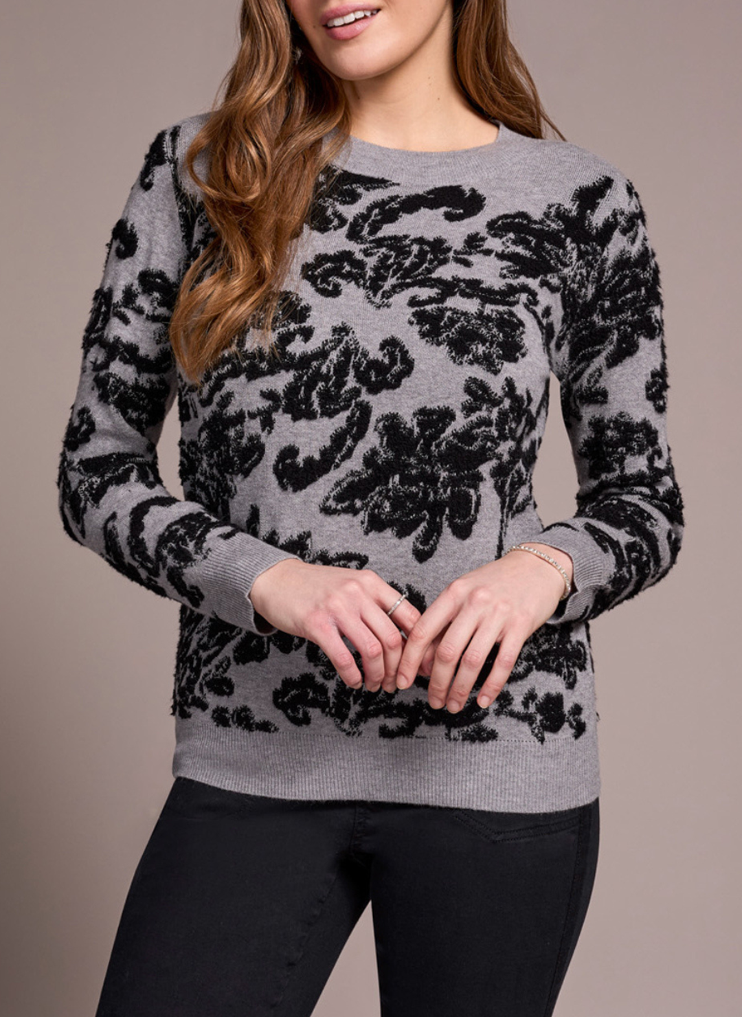 Model wearing Tribal Night Flower Crew Neck Sweater in grey with black floral jacquard pattern.