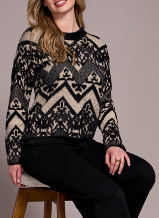 Front view of model wearing Tribal Albuquerque Sweater with black and beige geometric pattern, sitting on a stool.