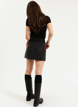 Back view of model wearing black studded denim mini skirt paired with tall boots.