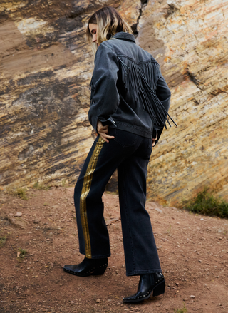 Side view of Porter Blue black wide leg denim showing dramatic leg opening and gold foil stripe detail along outseam