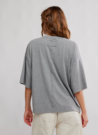 Person wearing a gray t-shirt with a plain background