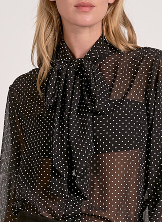 Elan Spot On Blouse in black sheer fabric with white polka dots and tie-neck detail.