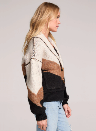 Woman wearing a multicolored cardigan on a plain background