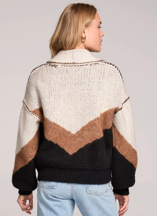 Person wearing a patterned sweater with a neutral background