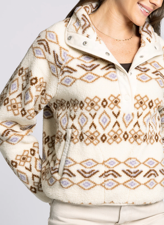 Person wearing a patterned jacket with a neutral background