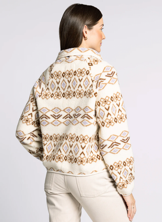 Woman wearing a patterned jacket on a plain background