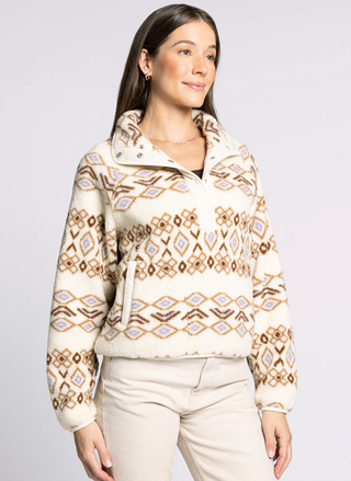 Woman wearing a patterned sweater against a plain background