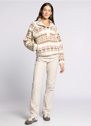 Woman wearing a patterned sweater and beige pants on a white background