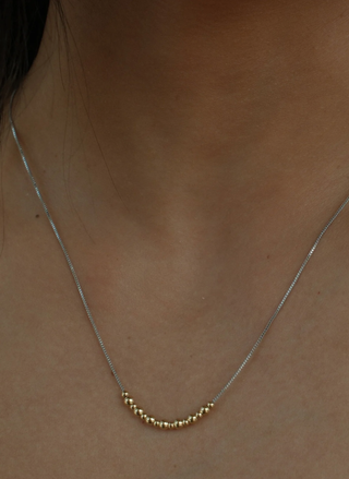 Model wearing Addison Mixed Metal Necklace featuring mixed metal beaded design.