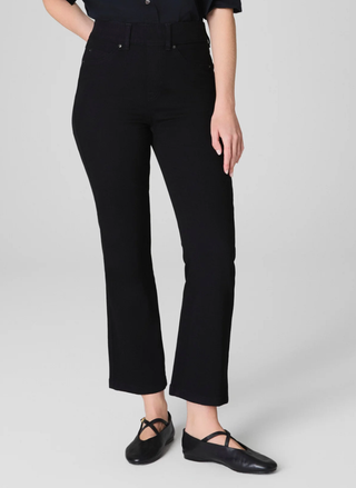 Person wearing black pants on a gray background