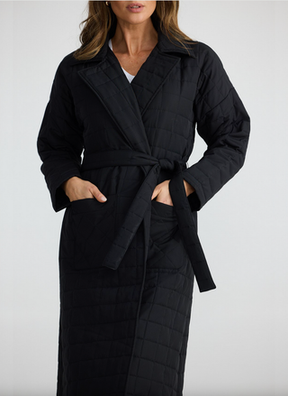 Front view of Bedford Longline Puffer in black with waist tie, worn by model