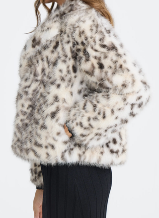 White fur coat with black leopard print pattern worn by a person on a white background