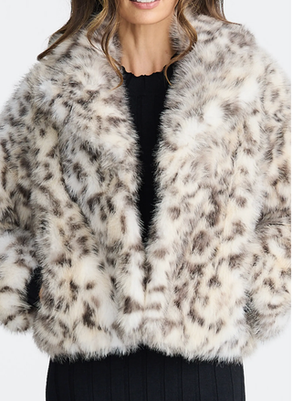 Close-up of a person wearing a fluffy white jacket with black patterns on a white background