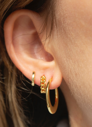 Gold FYB Corinne Chain Huggie earring styled in an ear stack with modern chain-link texture.