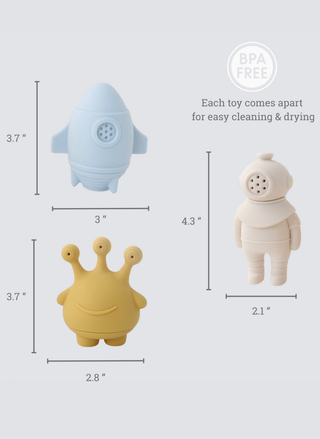 Dimensions of three toys including a blue rocket, yellow crown, and white figure on a light gray background.