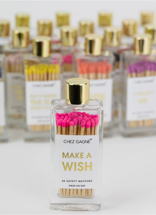 Bottle of matches labeled 'Make a Wish' with pink matches inside, on a white background.