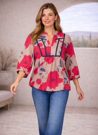 Model wearing Velvet Heart Zyler Shirt with red floral print and contrast trim, styled with blue jeans